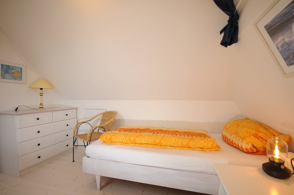Einzelbett mit Kommode in der Morgensünn