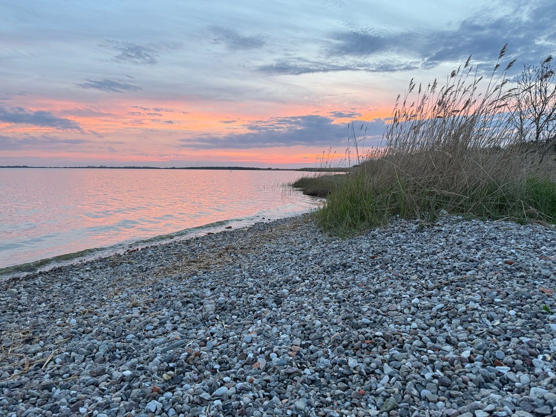 Sonnenuntergang über dem Bodden am Kiesstrand